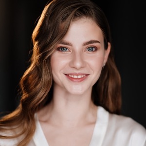 Smiling woman with long auburn hair in a white top